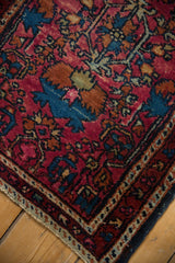 Vintage Lilihan rug corner, dark navy side cord, varied pile, intricate gem-tone vinery.