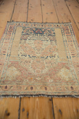 Faded floral pattern, worn pile, and black fringe on distressed Tabriz rug end.