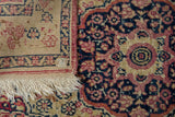 Close-up showing the hand-knotted foundation and intact red selvage of an antique Kerman rug.