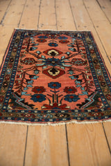 Delicate sapphire blue and wine red floral vines on dusty rose vintage Lilihan rug.