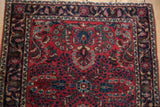 Corner of a fine German Sarouk rug with intricate floral sprays and a navy palmette border.