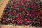 Angled view of the fine German Sarouk rug's corner, showing its floral palmette border.