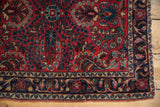 Flowing main border with floral palmettes and meandering vines on a vintage Persian Sarouk.