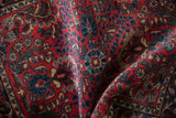 Soft folds reveal the dense, even pile and floral sprays of a vintage German Sarouk rug.