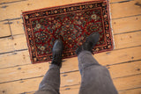 Vintage American Sarouk rug mat with intricate brick red and navy floral pattern underfoot.