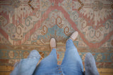 Distressed Soumac carpet with geometric motifs and halved medallions in dusty rose and blue.