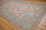 Distressed Soumac carpet detail showing abrash, geometric floral, and wave motifs.
