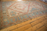 Distressed Soumac carpet border detail: reciprocating wave motif with powder blue, rose, and sand tones.