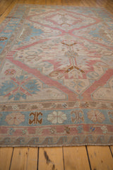 Distressed vintage Soumac carpet detail: wave border, geometric motifs in dusty rose, powder blue.