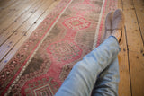 A relaxed view down a vintage Oushak runner with raspberry red and oxidized silver medallions.