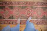A view from above of the distressed vintage Oushak runner's geometric pattern and soft texture.