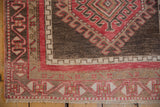 Geometric corner detail and intact side cord of a vintage distressed Oushak rug runner.