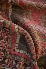 Soft, draped folds of a distressed Turkish rug with raspberry red and oxidized silver tones.