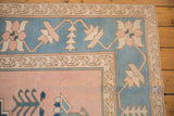 Corner of vintage Oushak carpet displaying wide ivory border, powder blue, and dusty blush field.