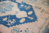 Distressed cobalt and powder blue stepped medallion on a dusty blush Oushak pile.