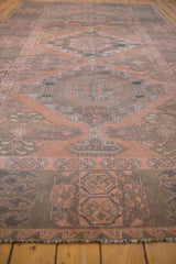 Distressed Soumac carpet detail: dusty blush, charcoal, green geometric motifs.