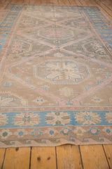 Vintage distressed Soumac carpet detail with reciprocating medallions in dusty rose.