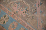 Distressed vintage Soumac carpet with sky blue, dusty rose geometric motifs and wave border.