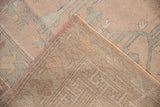 Corner detail of distressed Oushak showing worn rose and silver pile, visible foundation, and original selvage.