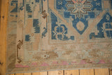 Distressed Soumac carpet detail highlighting blue, beige, and pink wave motif border.