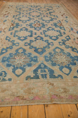 Distressed Soumac carpet with indigo blue, beige geometric lattice and floral bouquet motifs.