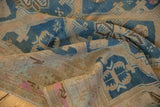 Hand-woven distressed Soumac carpet detail showing geometric patterns, soft indigo blue, and beige.