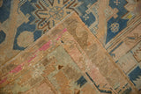Distressed vintage Soumac carpet corner revealing textured flatweave reverse and colorful indigo, pink, beige.