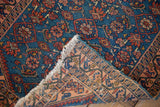 Hand-knotted Persian Malayer rug corner, showcasing sapphire blue Herati pile and detailed peach foundation.