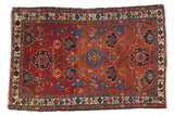 Antique Persian Malayer rug with madder red Harshang field, deep blue floral and animal motifs.