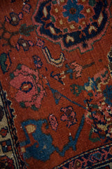 Worn Harshang floral motifs on the antique Malayer rug's madder red field.