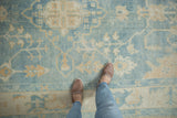 Distressed Oushak rug showing soft blue wool, ivory vinery, and subtle abrashes.
