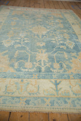 Distressed Oushak pile texture, with soft powder blue and ivory floral vinery.