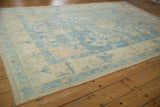 Soft powder blue and ivory border detail on a distressed vintage Oushak rug with intact selvage.