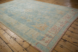 Distressed Turkish Oushak rug corner with terracotta border, powder blue field, and unique abrashes.