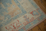 Distressed Turkish Oushak rug detail: powder blue, ivory, terracotta tones, stylized vinery, intact selvage.