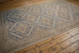 Detail of vintage distressed Soumac carpet showing geometric border and muted cobalt blue lattice.