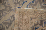 Distressed beige Soumac carpet with geometric pattern, abrashes, and visible hand-woven flatweave back.