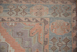 Vintage Soumac rug corner detail, with faded blush, powder blue, and mauve geometric patterns.