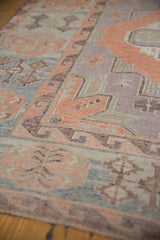 Textured vintage distressed Soumac carpet with angular patterns in dusty blush and pale blue.