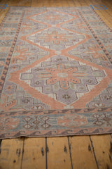 Hand woven Soumac carpet's geometric borders in faded blush, mauve, and powder blue.
