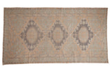 Distressed Vintage Soumac carpet, triple geometric medallions, muted beige and slate blue tones.