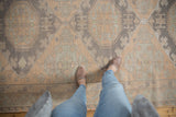 Distressed vintage Soumac carpet with geometric medallions and floral guls in beige and slate blue.