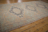 Distressed Soumac carpet edge with pale sandalwood and slate blue reciprocating wave motif.