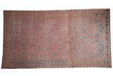 Vintage distressed Soumac rug runner with hexagonal floral medallions in raspberry, dusty slate blue, and mauve.