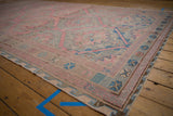 Angled view of a vintage Caucasian Soumac runner displaying its pink and blue hexagonal medallions.