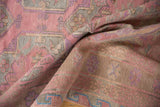 Textured flatweave of a vintage Soumac rug with pink, mauve, and slate blue geometric florals.