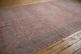 Flatweave texture and hexagonal floral medallions on a distressed pink Caucasian Soumac rug.