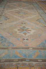 Distressed vintage Soumac runner displaying geometric diamond motifs and bird design border.