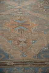 Distressed flat weave Soumac rug with geometric diamond and floral motifs in muted blue and rust.
