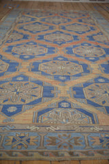 Distressed Soumac carpet, geometric paneled medallions, abrash texture in terracotta and blue.